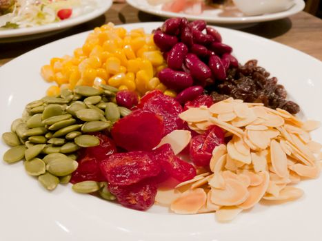 Pile of the steam yellow corn, red bean, sunflower seed, almond, raisin and sweet dried jujube, salad and healthy food