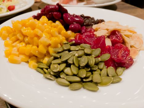 Pile of the steam yellow corn, red bean, sunflower seed, almond, raisin and sweet dried jujube, salad and healthy food