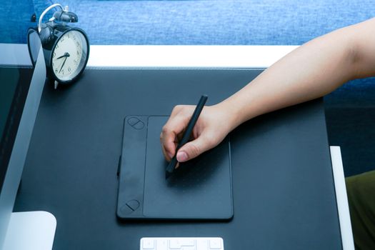 Focus on the busy graphic designer working on computer by digital pen mouse