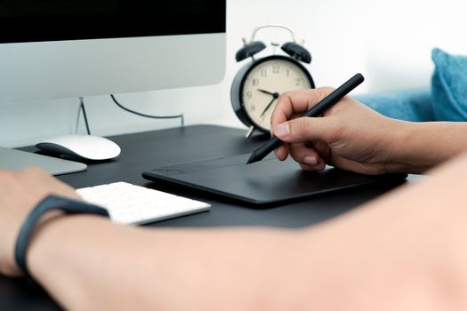 Focus on the busy graphic designer working on computer by digital pen mouse