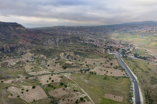 The mountains of Cappadocia impress with their nakedness and openness. Balloons rise above them.