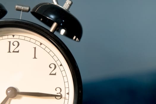 closeup the black vintage clock face on blue backgrounds