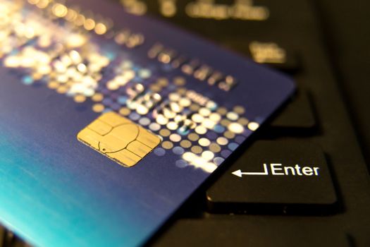 closeup credit card on black enter button, convenience shopping concept