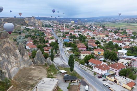 View of dozens of balloons flying over the valleys of Cappadocia at dawn in central Turkey.