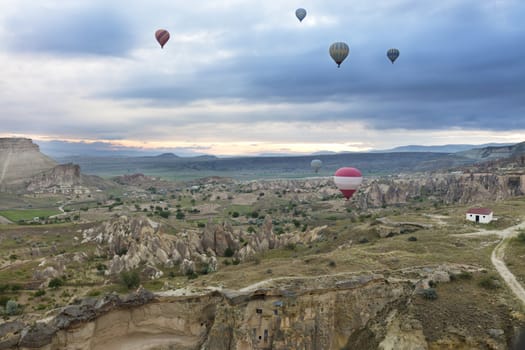 A view of several balloons flying over the valleys of Cappadocia at dawn in central Turkey.