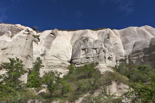 Red and white sandstone cliffs, ancient caves in a mountain landscape between valleys in Cappadocia, central Turkey