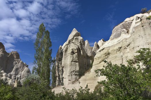 Red and white sandstone cliffs, ancient caves in a mountain landscape between valleys in Cappadocia, central Turkey