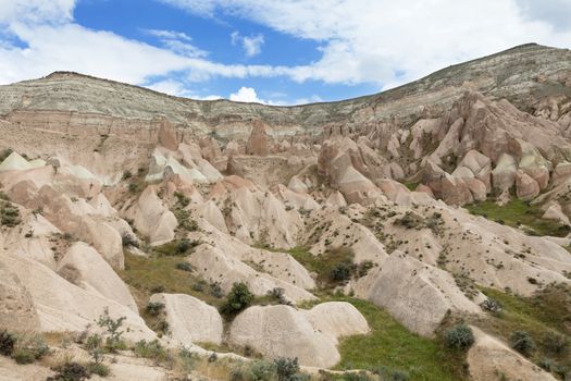 Red and white sandstone cliffs, ancient caves in a mountain landscape between valleys in Cappadocia, central Turkey