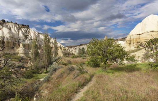 Red and white sandstone cliffs, ancient caves in a mountain landscape between valleys in Cappadocia, central Turkey