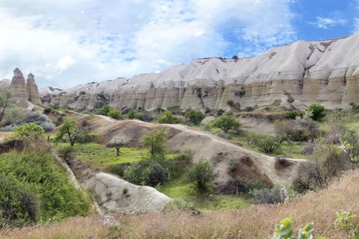 Red and white sandstone cliffs, ancient caves in a mountain landscape between valleys in Cappadocia, central Turkey