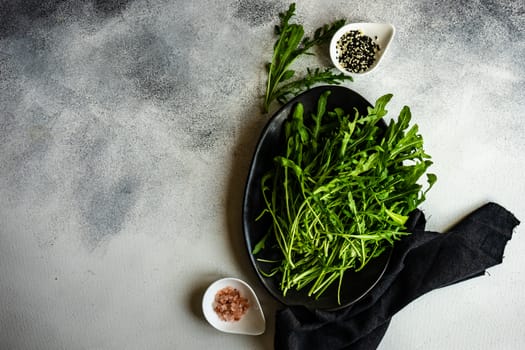 Healthy food concept with fresh organic arugula herb leaves on stone background with copy space