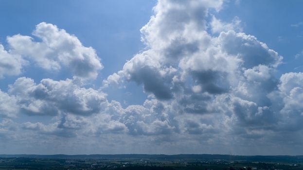 White and Dark Fluffy Clouds Floating in the Bright Blue Skies on a Summer Day