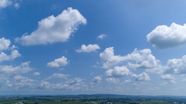 White Fluffy Clouds Floating in the Bright Blue Skies on a Summer Day