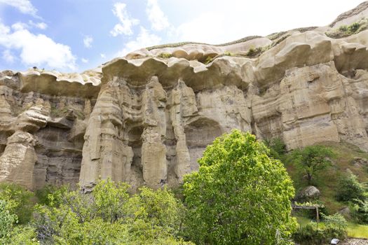 Red and white sandstone cliffs, ancient caves in a mountain landscape between valleys in Cappadocia, central Turkey