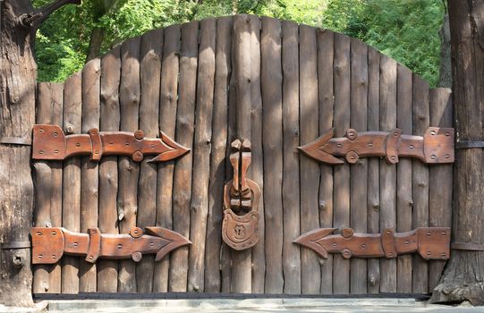 The old and mysterious wooden gate is closed to a large wooden castle - this is the entrance to the magic forest
