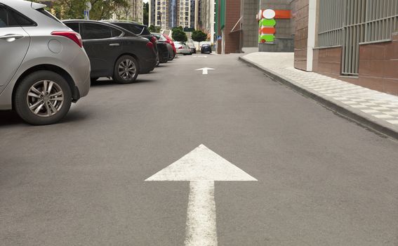 Road marking, arrow on the asphalt indicates the direction for driving vehicles near the local area