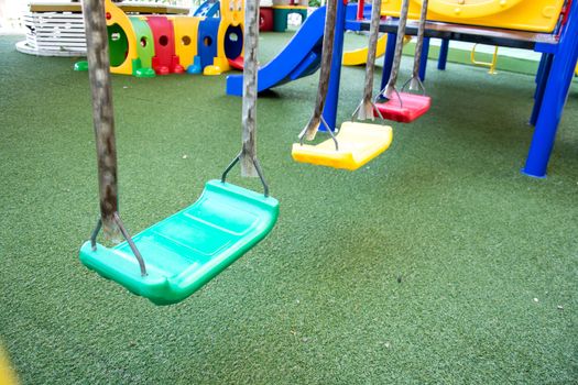 Empty chain swings on summer kids playground