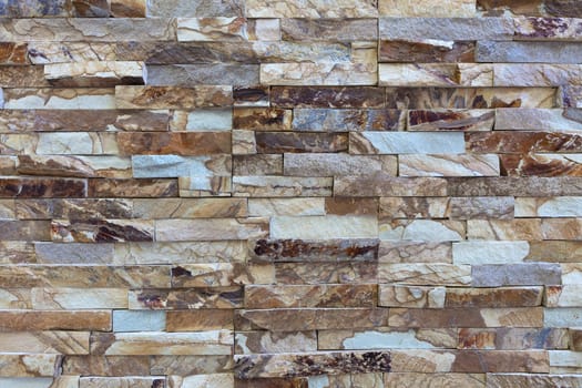 Wall stone mosaic made of golden sandstone texture