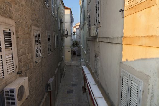 The old town of Budva in Montenegro, early morning, the sun creeps on a narrow street.