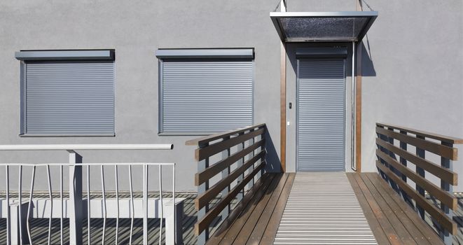 Light gray metal blinds on the doors and windows of the house