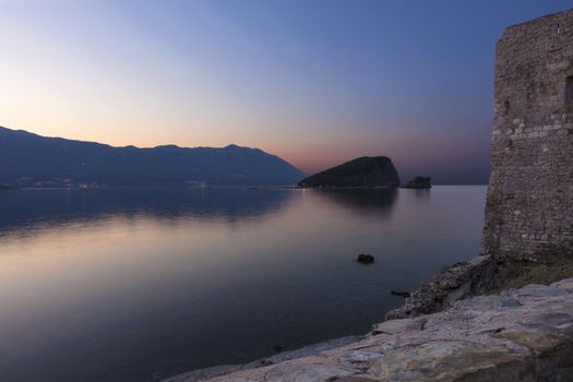 View of the island of St. Nicholas in the Adriatic Sea from the fortress of the ancient Citadel in the early summer morning. The Budva Riviera. Beautiful panoramic landscape of nature.