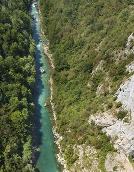 The pure turquoise water of the mountain river overcomes the stone rapids in the national park of central Montenegro. Ecology concept.