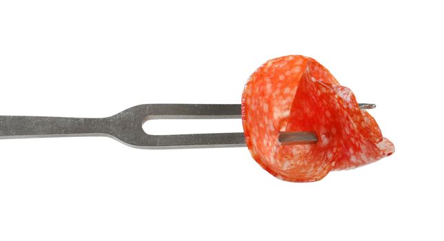 Slice of Hungarian salami on fork isolated on white