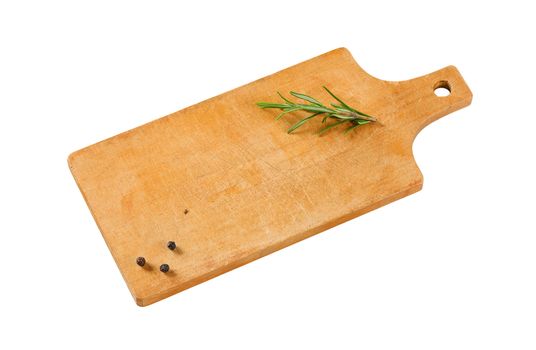 Wooden cutting board with rosemary and black peppercorns on it