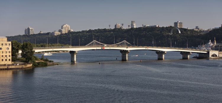 View of the Havana Bridge across the Dnipro River in Kiev in the rays of the evening sunset