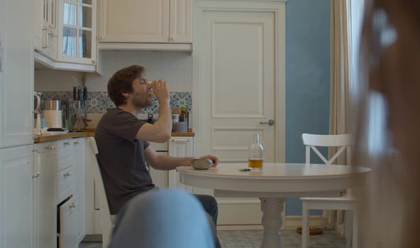Man drinking alcohol at home in the kitchen