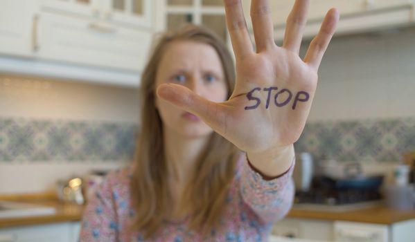 Young woman showing stop sign on the hand. Movement against sexual harassment.