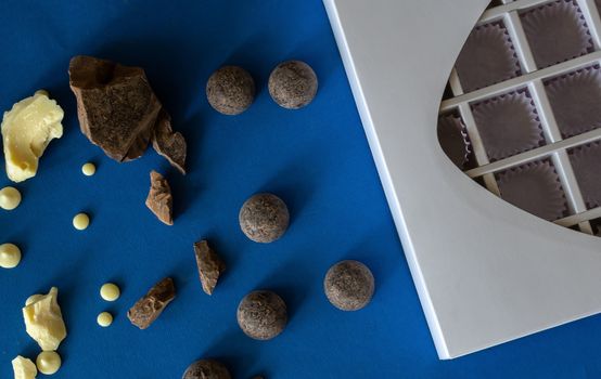 Pieces of chocolate on a blue background. Ingredients for making healthy and delicious sugar-free sweets at home. Home made chocolate for valentine day gift or other holidays