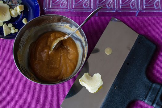 Close-up of a professional artisan pastry shop. A piece of white chocolate is prepared for home cooking useful and delicious sweets