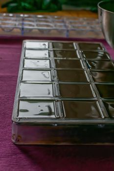 The molds are filled with liquid chocolate mass. The process of home cooking healthy sweets without sugar.