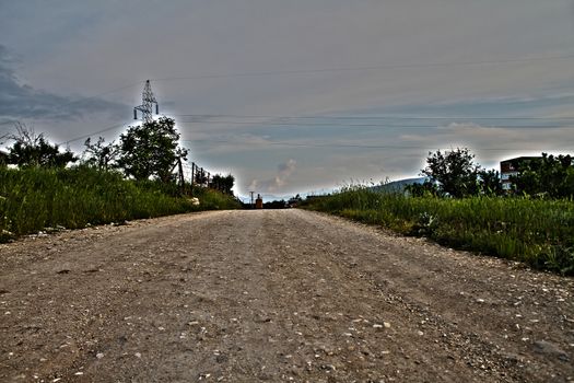 Long straight road with dramatic clouds