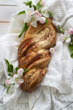 Wicker bun top view with flowers of apple on white vintage table