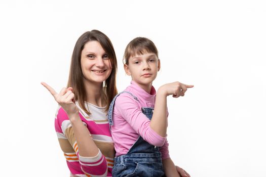 The girl joyfully points a finger in one direction, the girl is sad in the other