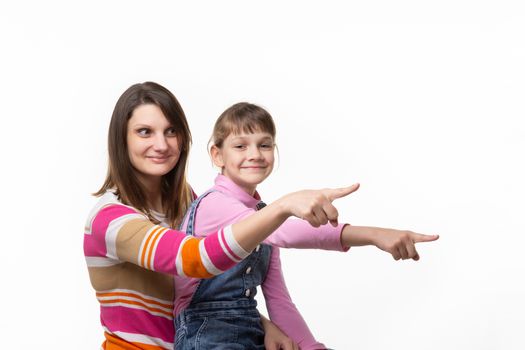 Mom and girl point a finger to an empty place