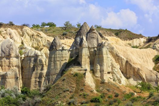 Cone-shaped cliffs of red and white sandstone in the landscape of valleys in Cappadocia, central Turkey