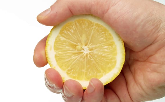 Close up male hand squeezing a lemon on white background.