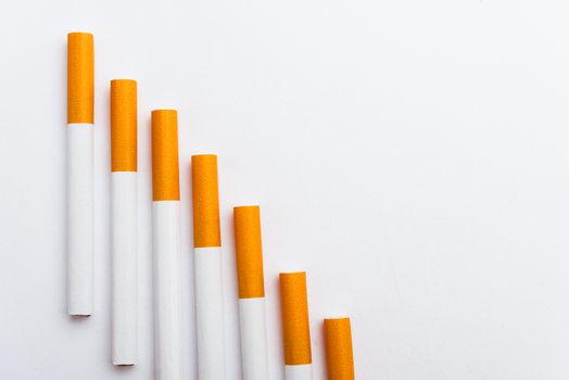 31 May of World No Tobacco Day, Close up step staircase pile cigarette or tobacco on white background with copy space, Smoking reduction campaign and Warning lung health concept