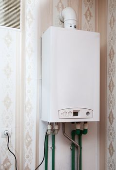 white metal boiler on the wall in the kitchen closeup