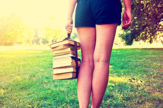Girl holding a stack of books. Education. Back to school. Instagram vintage picture.