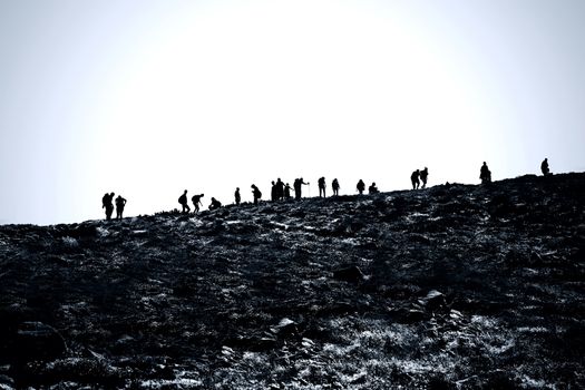 Tourism in mountains. A lot of tourists climb into top of the mountain.