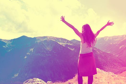 Happy teenage girl feel freedom in mountains scenery. Vintage instagram picture.
