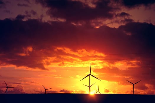 Windmills on the farm and sunset. Alternative ecological energy.