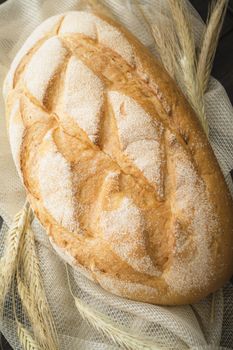 Freshly baked traditional bread with golden ears, vertical