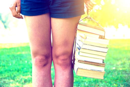 Girl holding a stack of books. Education. Back to school. Instagram vintage picture.