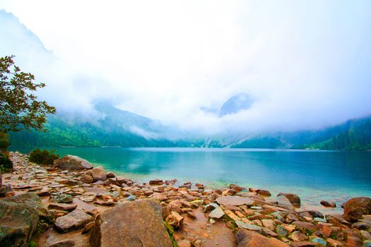 Fog over lake in mountains. Fantasy and colorfull nature landscape. Nature conceptual image. Morskie Oko in Tatry, Poland.