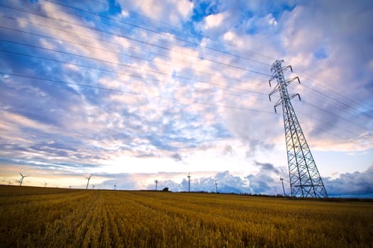 Field and sky with clouds and high voltage post. Landscape conceptual image.